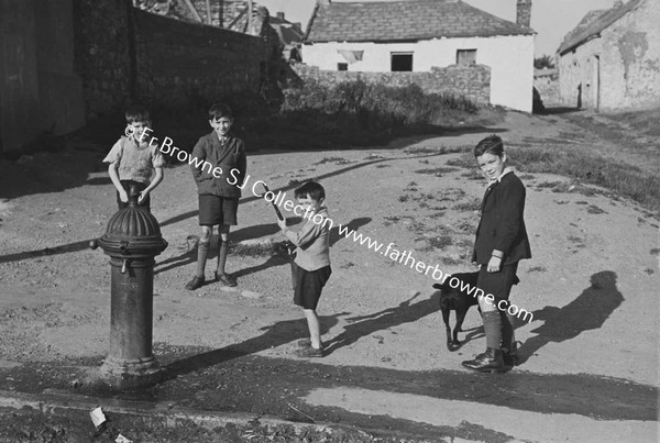 CHILDREN PLAYING IN STREET AROUND WATER PUMP